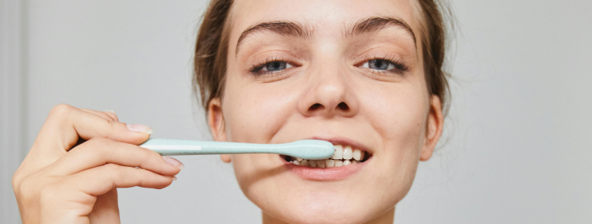 fair-skinned woman brushing teeth