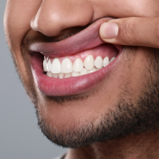 Man,Showing,Healthy,Gums,On,Grey,Background,,Closeup man showing off healthy gums